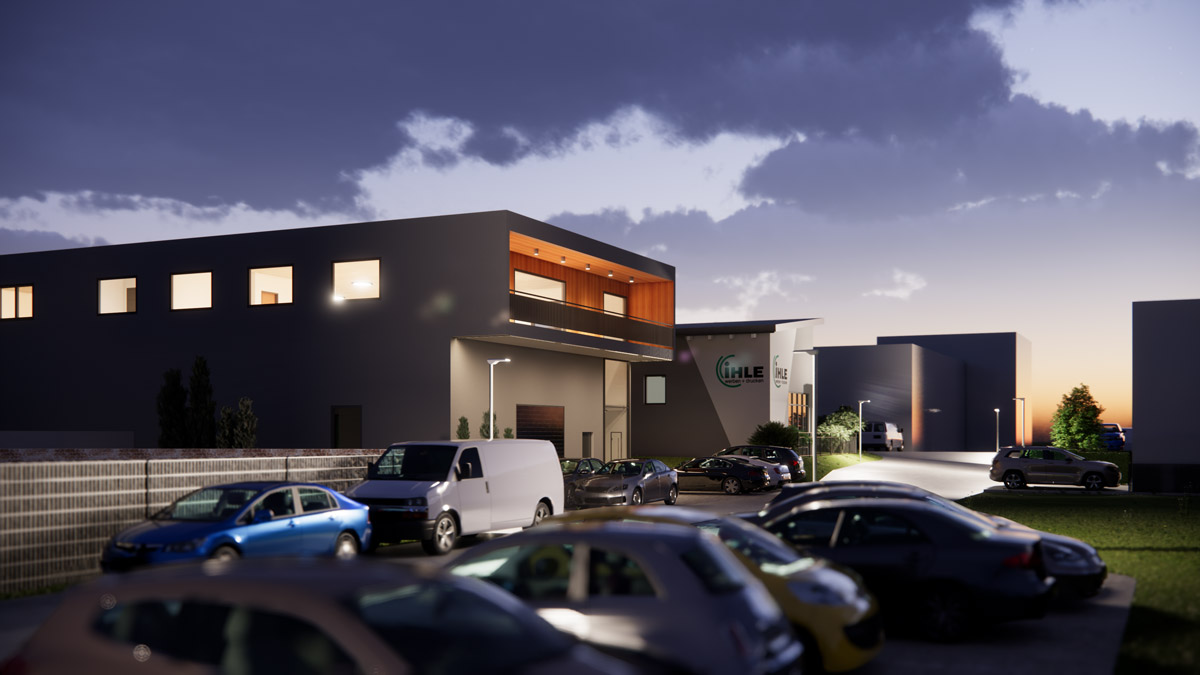 Modernes dunkles Firmengebaeude mit beleuchteten Fenstern und Parkplatz bei Daemmerung